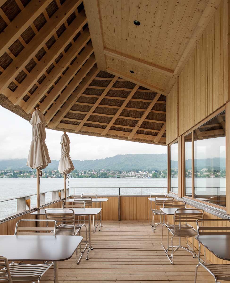 Von der seitlichen Restaurantterrasse eröffnen sich Ausblicke über den See sowie Einblicke ins Dachtragwerk und die Schilf-Bedeckung. Bild: Juliet Haller / Amt für Städtebau